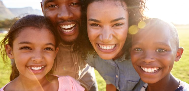 laughing-black-family-outdoors-close-up-back-lit-PPCMZD4.jpg